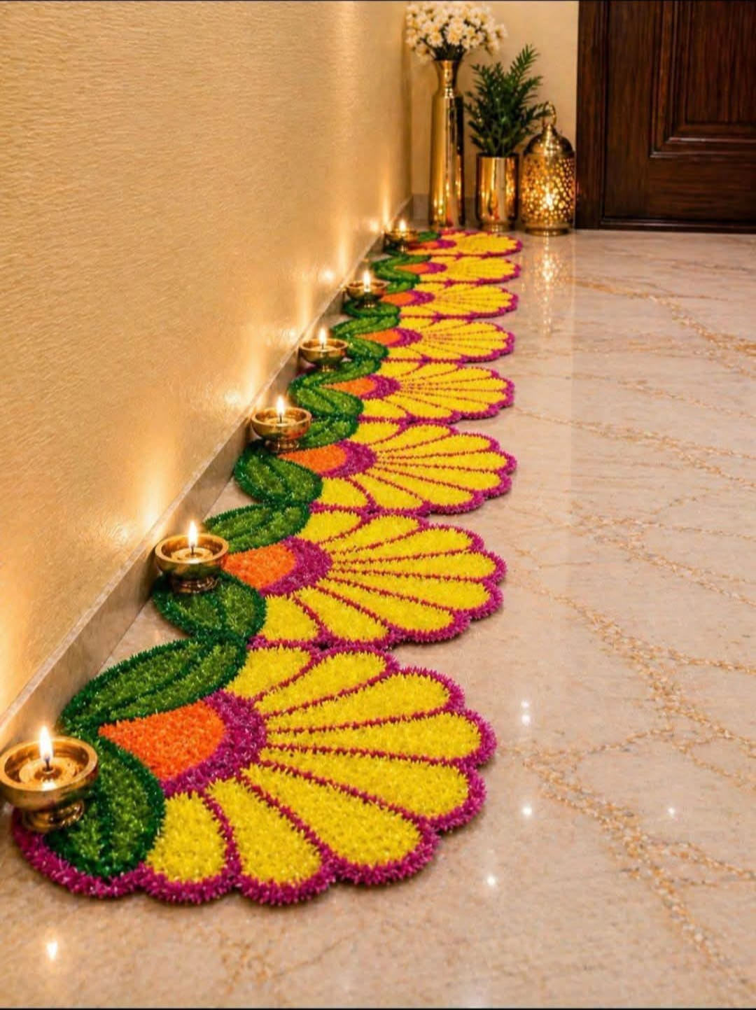 Handmade marigold flower rangoli mats laid along a hallway with diyas